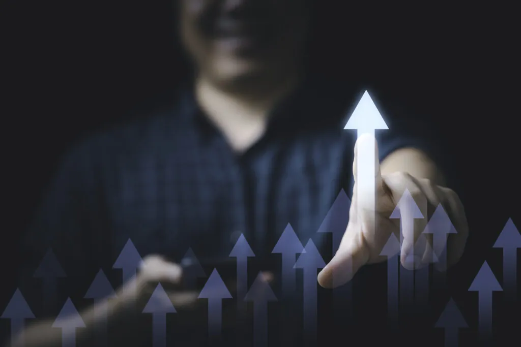 Empresário tocando em uma seta de crescimento sobre um gráfico