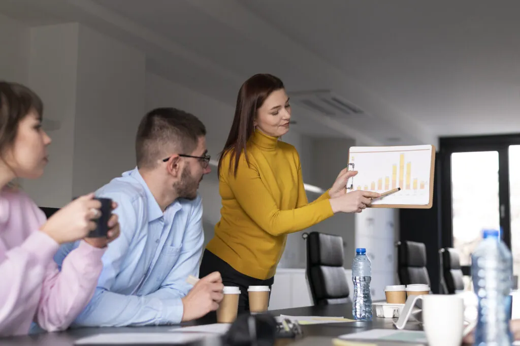 Equipe de trabalho em reunião apresentando um gráfico