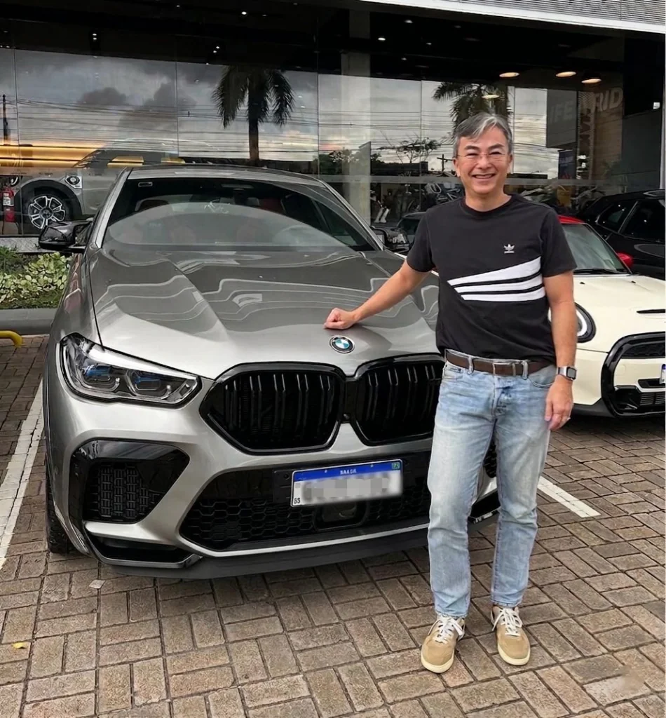 Empresário ao lado de um carro de luxo, analogia sobre preparo para liderar